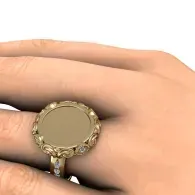 Hand with ornate gold ring featuring a round beige center stone