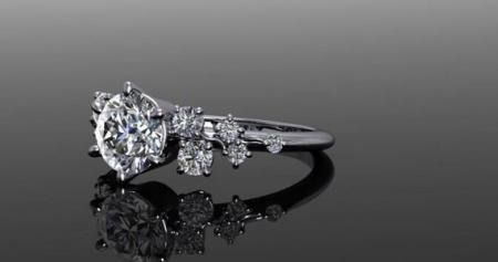 Diamond engagement ring on a glossy black surface with a mirrored reflection