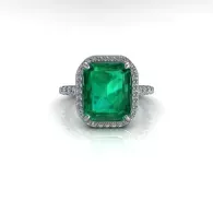 Emerald-cut green gemstone ring with a silver halo setting