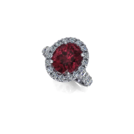 Oval red gemstone ring with a halo of clear stones on a silver band