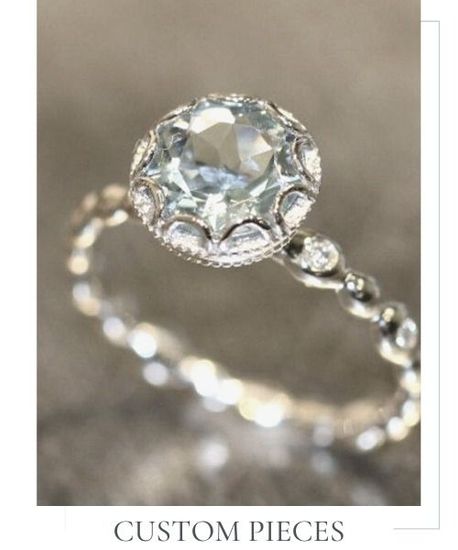 Custom silver ring with a clear gemstone on a soft gray background