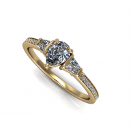 Gold engagement ring with a round diamond and two side stones on a white background