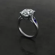 Silver ring with a large clear gemstone and a small blue accent on a dark background