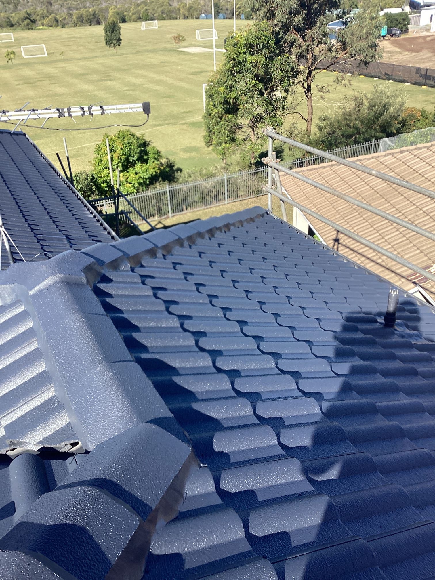 Dark Blue Tiled Roof With a View of a Sports — Over the Top Roofing Specialists in Kunda Park, QLD