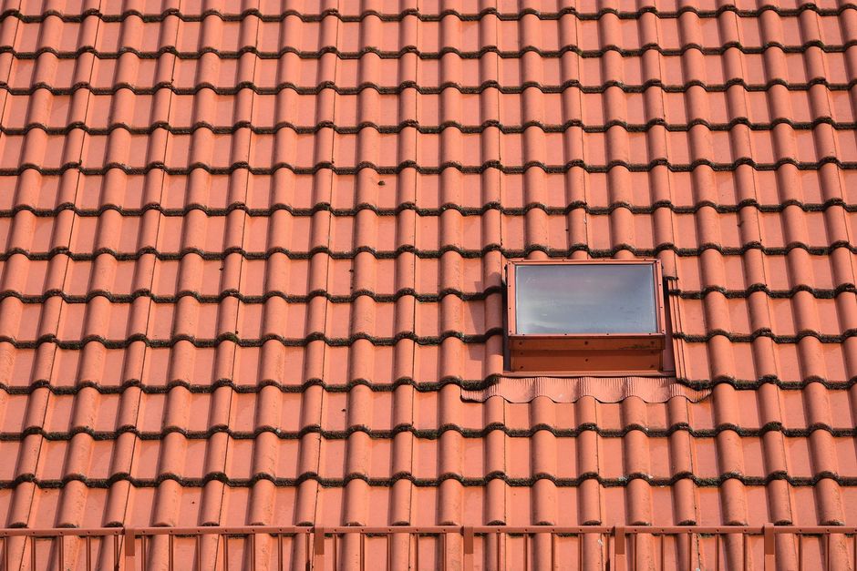 Red-tiled roof with a small skylight window in the center