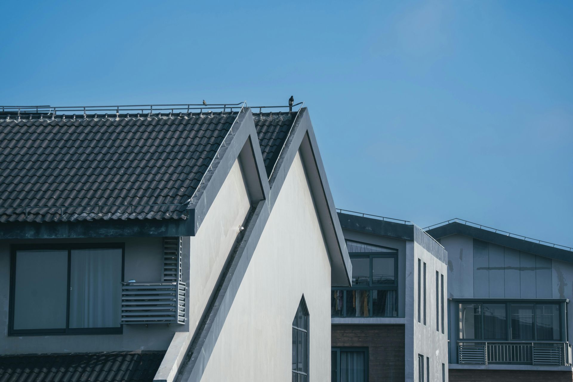 Modern houses with sloped roofs under a clear blue sky
