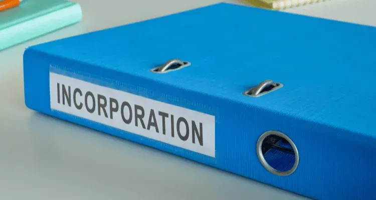 Blue binder labeled “INCORPORATION” with a metal ring hole on a white surface
