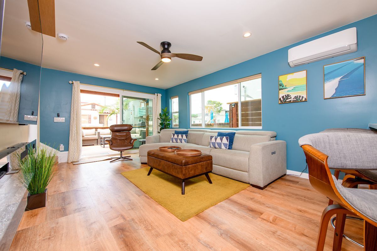 A living room with a couch , chair , table and ceiling fan.