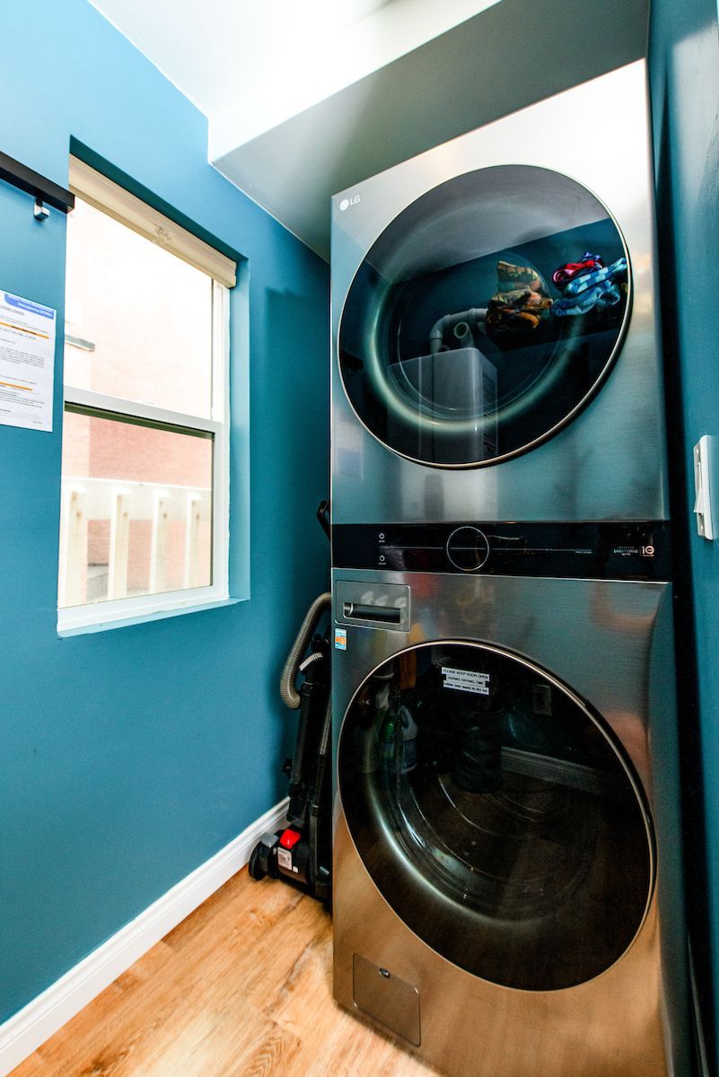 A washer and dryer are stacked on top of each other in a laundry room.