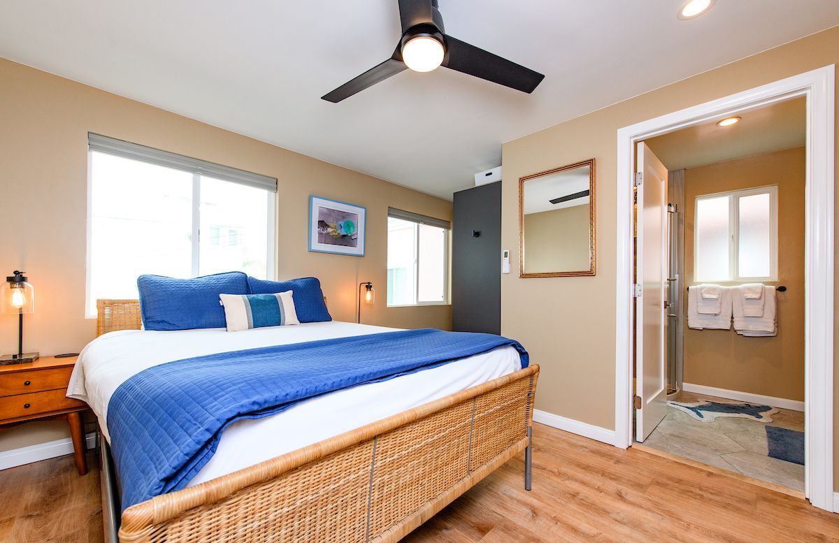 A bedroom with a king size bed and a ceiling fan.
