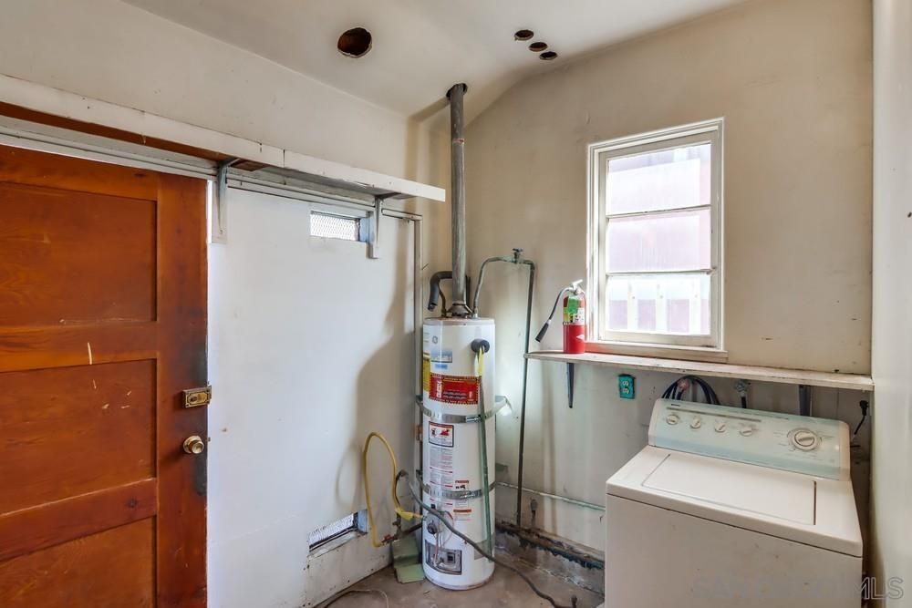 A laundry room with a washer and dryer and a water heater.