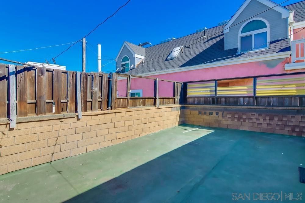 A building with a brick wall and a fence in front of it.