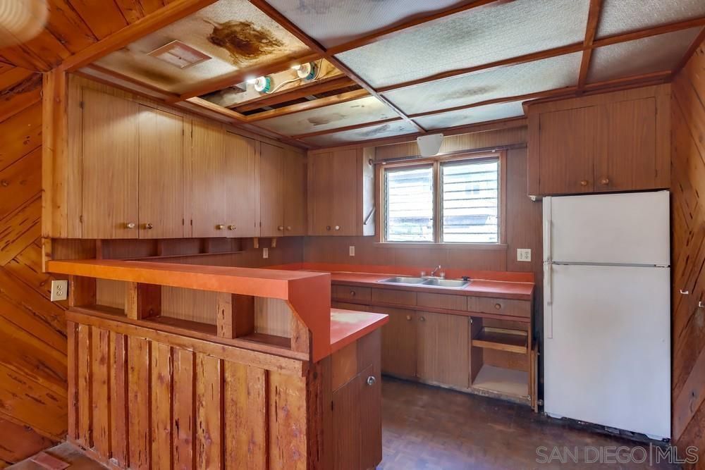 A kitchen with wooden cabinets and a white refrigerator