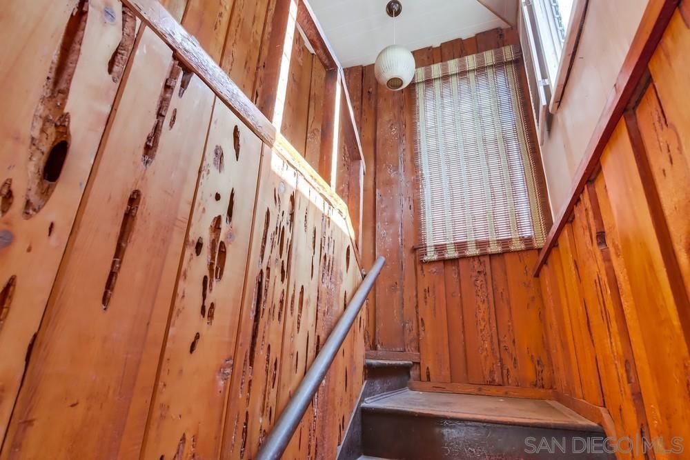 A wooden staircase with a metal railing and a window