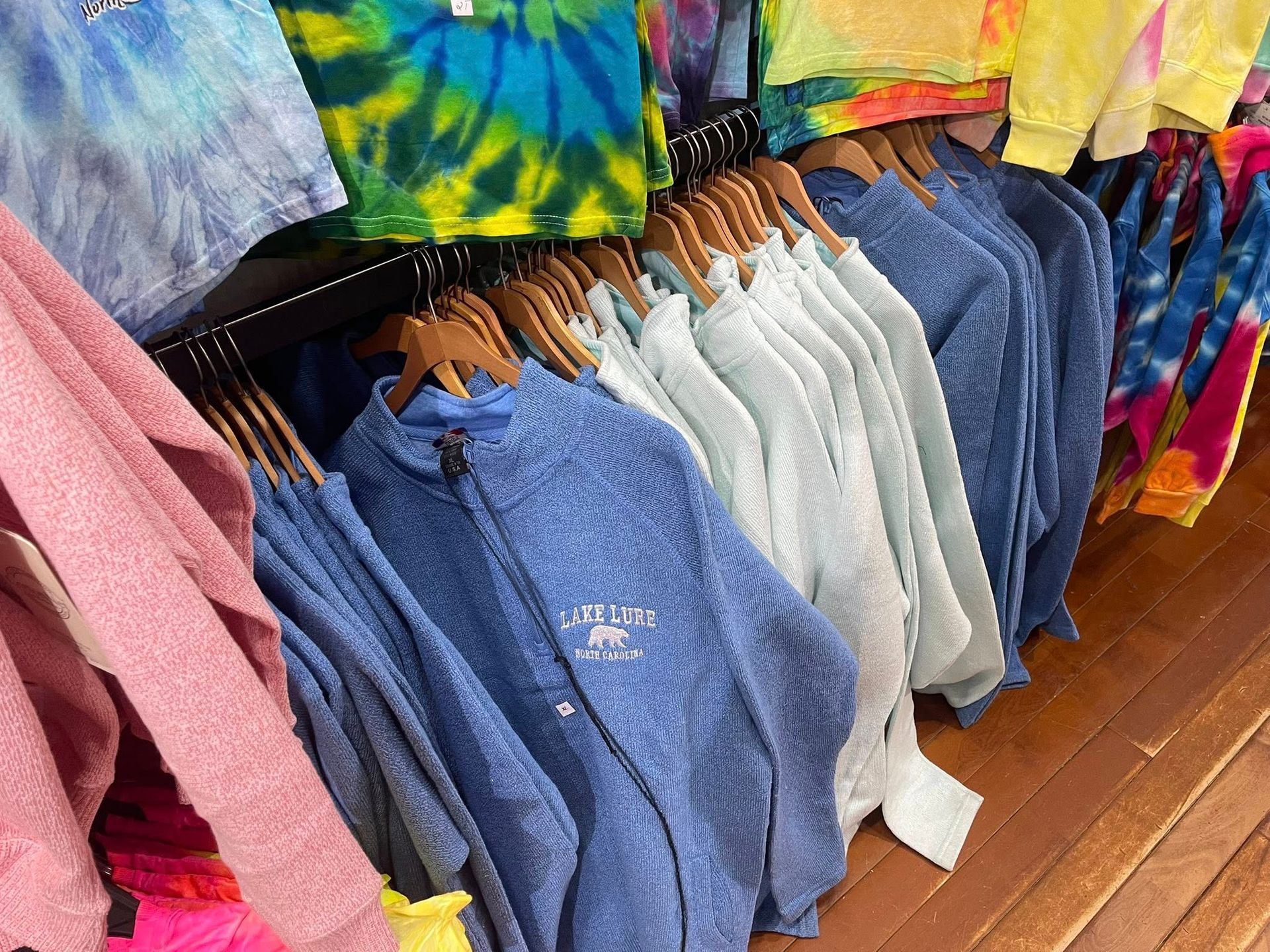 Crewneck sweatshirts with local mountain town embroidery on a rustic display table.