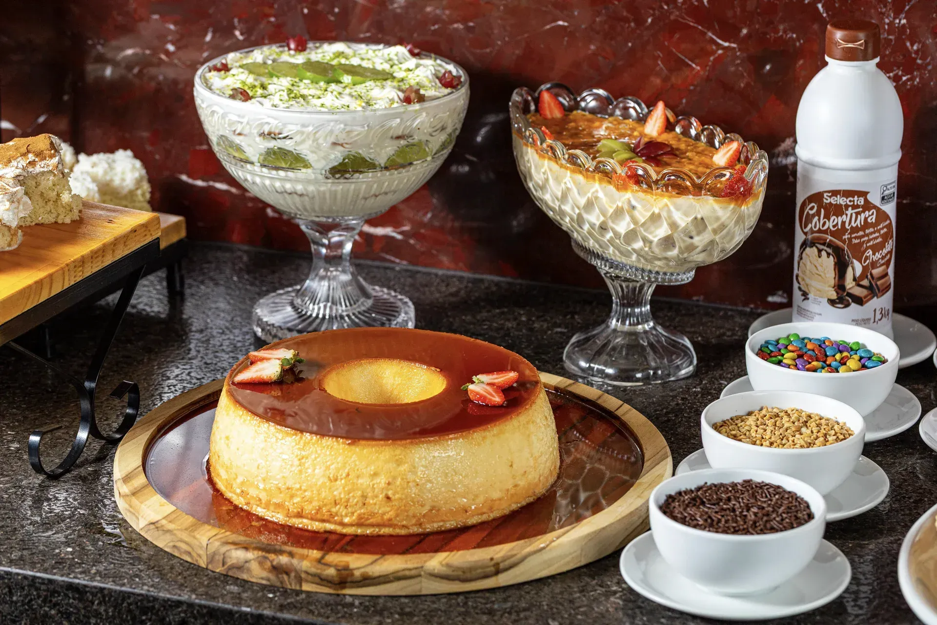 Uma mesa coberta com uma variedade de sobremesas e tigelas de coberturas.