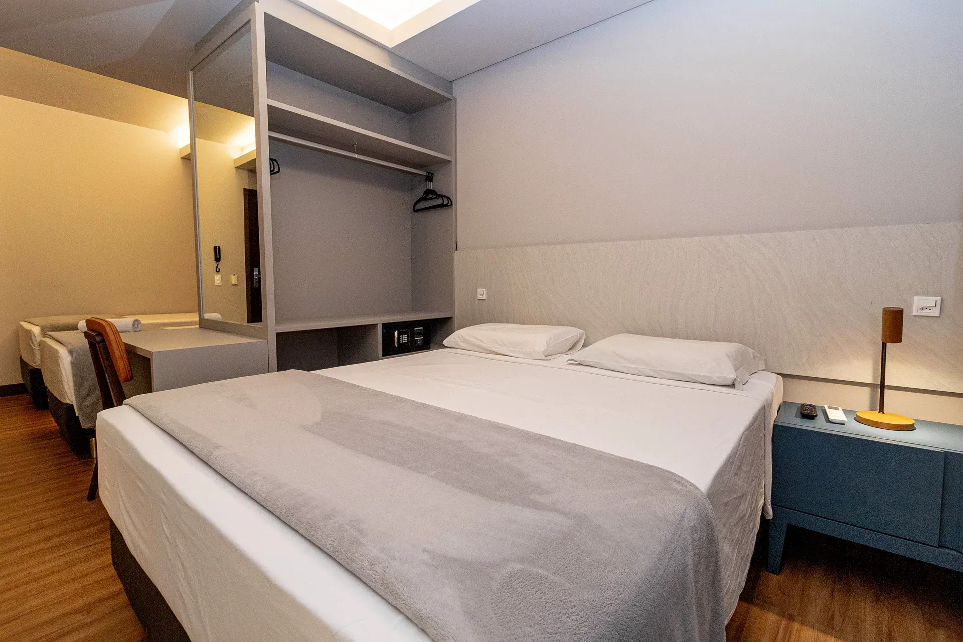 Um quarto de hotel com uma cama king size e duas camas de solteiro.