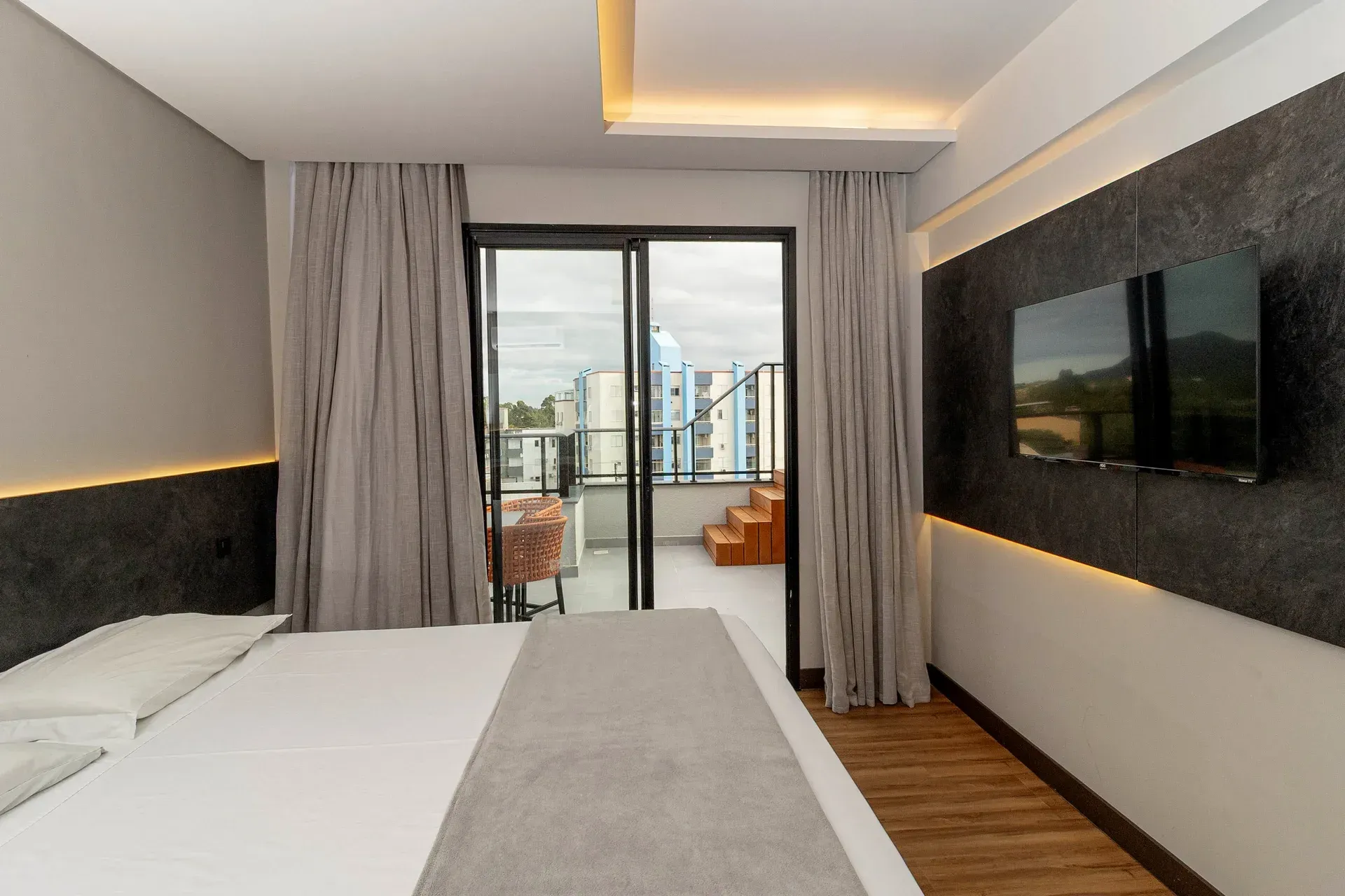 Um quarto de hotel com uma cama king size e uma TV de tela plana.