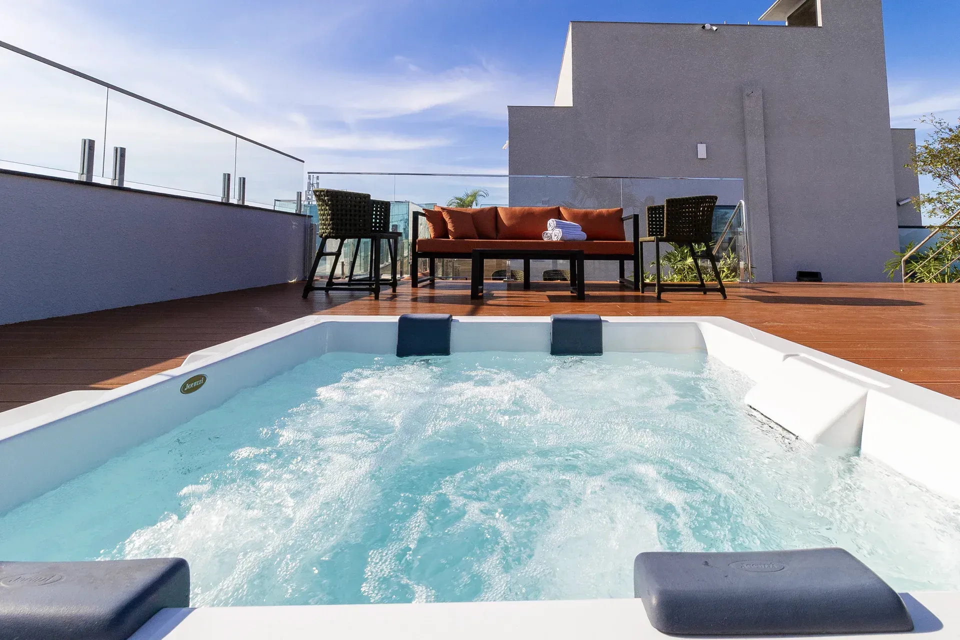 Uma piscina com um sofá e cadeiras ao fundo