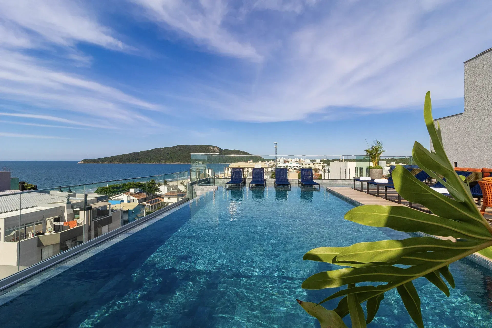 Uma grande piscina no topo de um edifício com vista para o oceano.