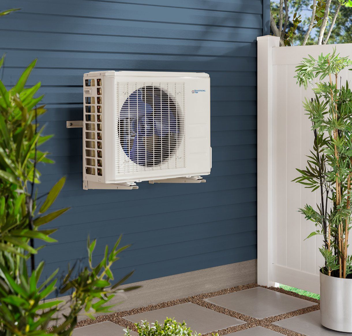 A white air conditioner is mounted on a blue wall