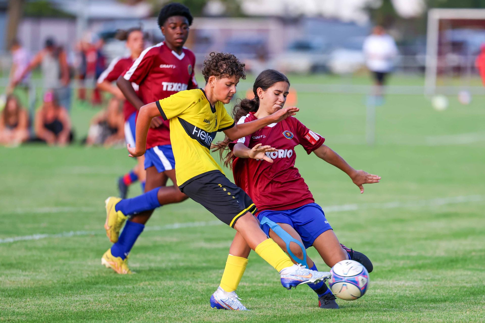 Un groupe de jeunes garçons jouent au football sur un terrain.