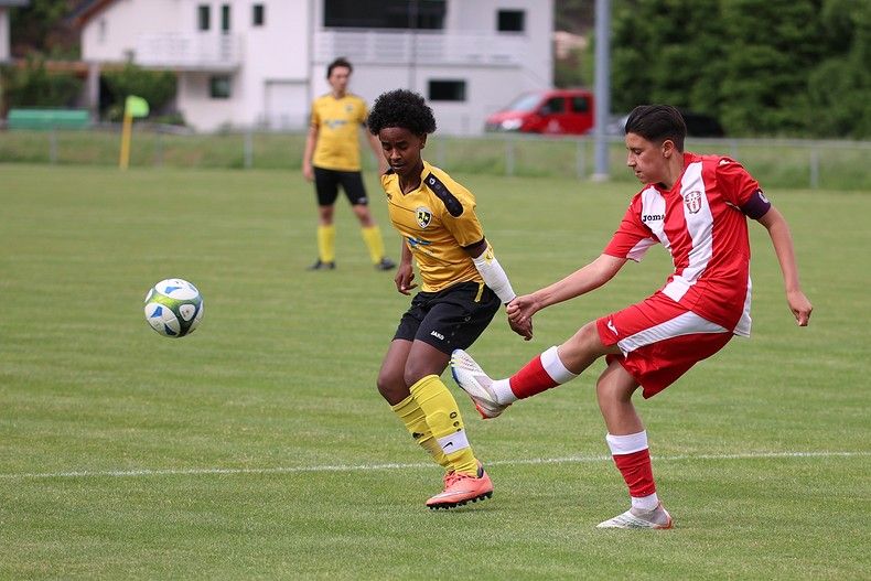 Deux joueurs de football jouent à un match de football sur un terrain.
