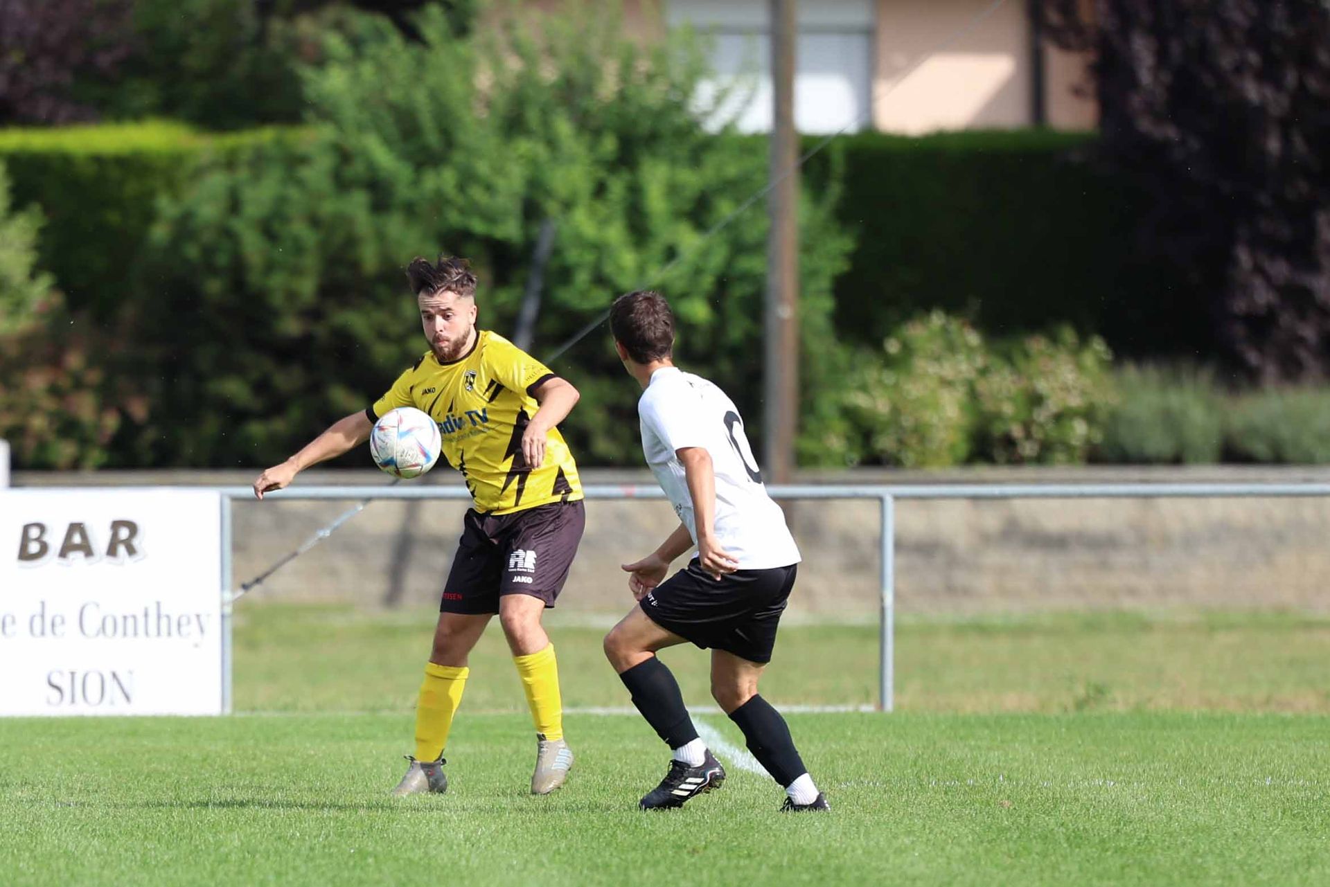 Deux joueurs de football jouent à un match de football sur un terrain.