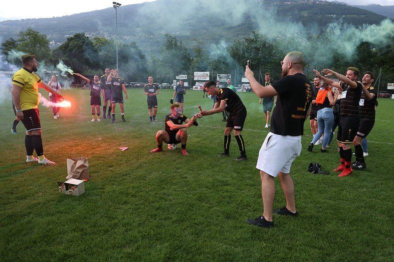 Un homme prend une photo d'un groupe de joueurs de football sur un terrain.