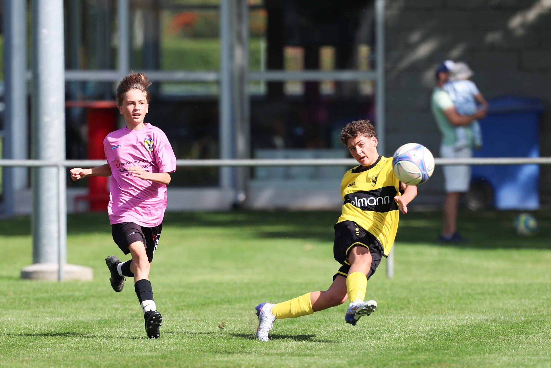 Deux jeunes garçons jouent au football sur un terrain.