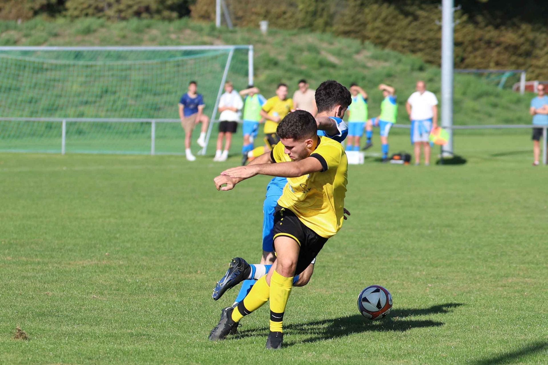 Un groupe de jeunes hommes jouent au football sur un terrain.