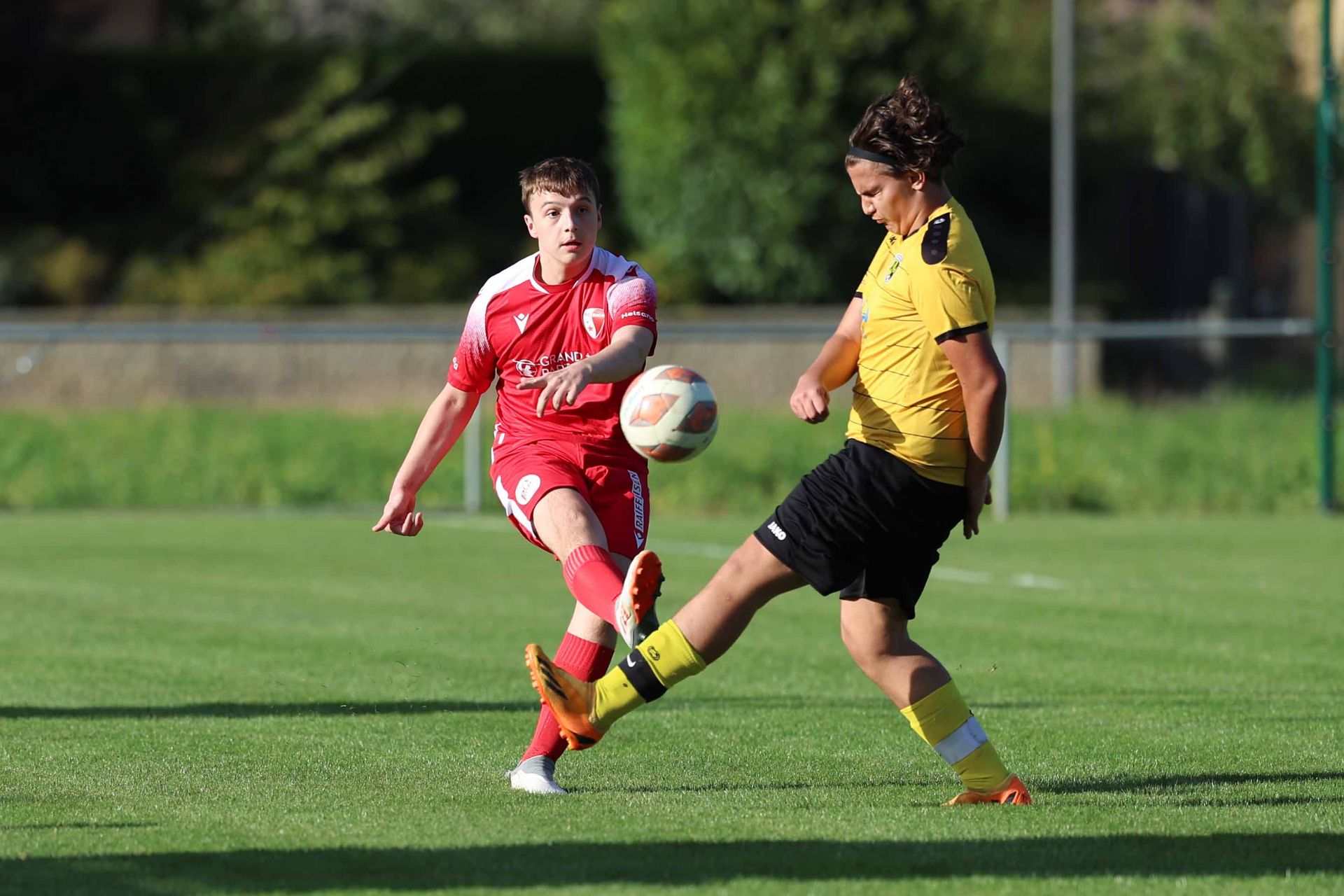 Deux joueurs de football jouent à un match de football sur un terrain.