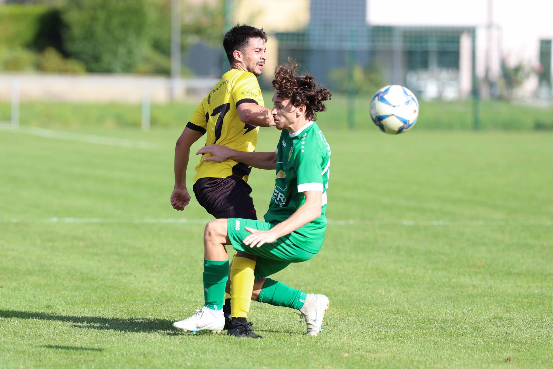 Deux joueurs de football jouent à un match de football sur un terrain.