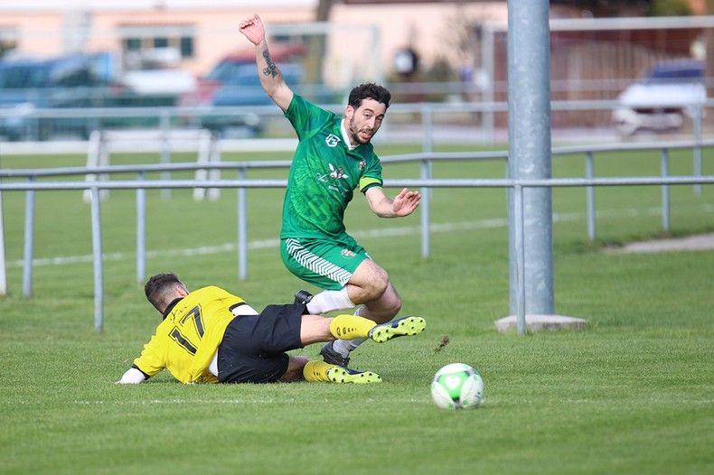 Deux joueurs de football jouent à un match de football sur un terrain.