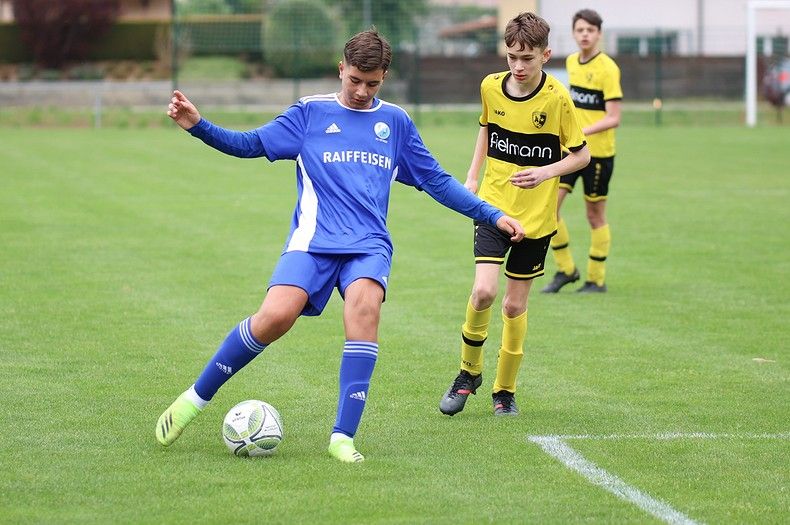 Un groupe de jeunes hommes jouent au football sur un terrain.