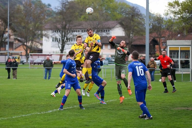 Un groupe de joueurs de football jouent à un jeu sur un terrain.