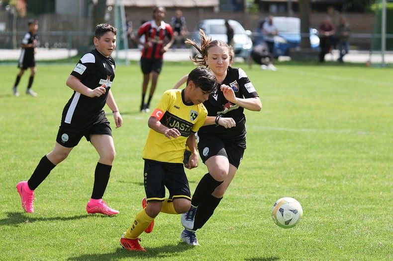 Un groupe de jeunes filles jouent au football sur un terrain.