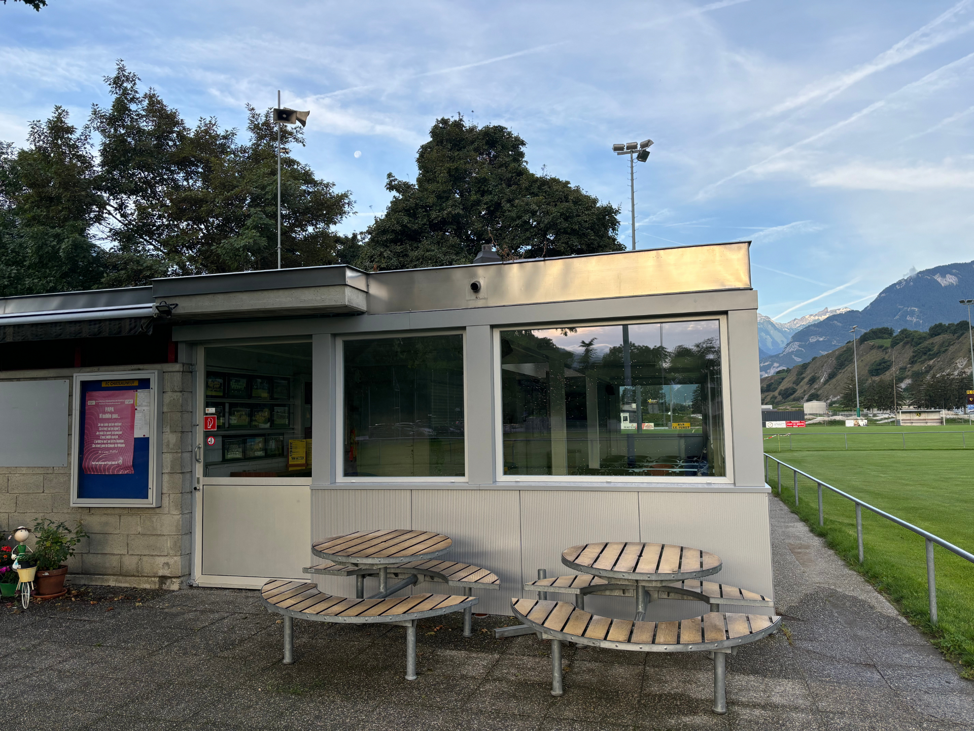 Un bâtiment avec beaucoup de fenêtres et de tables devant lui.