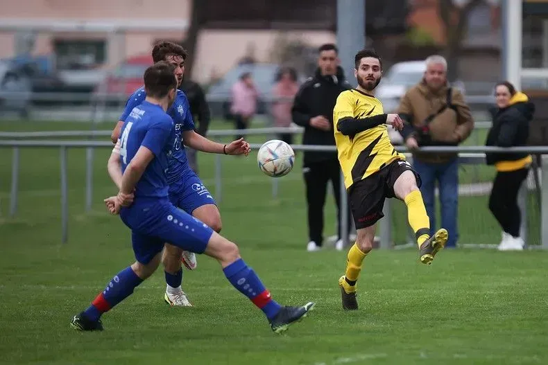 Un groupe de joueurs de football jouent à un jeu sur un terrain.