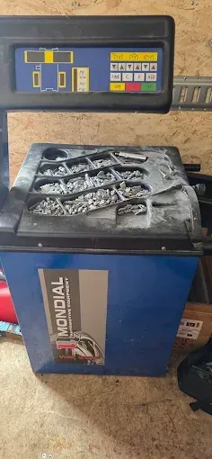 Machine industrielle bleue et noire avec un panneau de commande et un plateau de déchets métalliques sur le dessus
