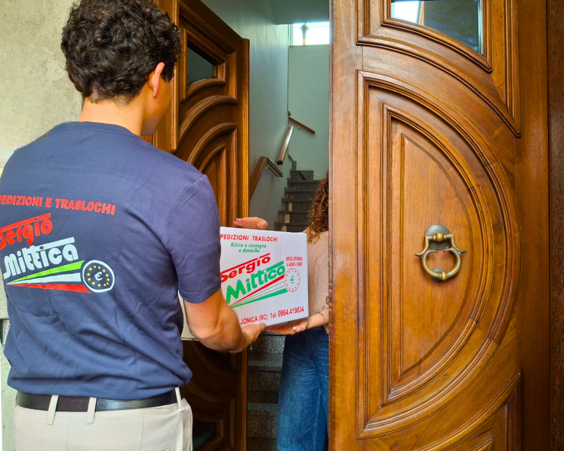 Persone che scaricano un camion per traslochi bianco con logo colorato e scritta “Spedizioni & Traslochi”.