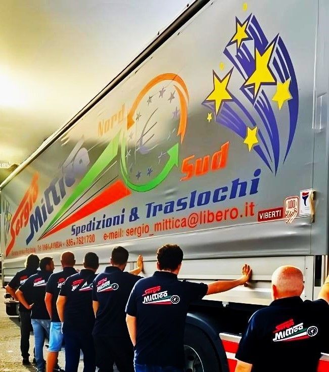 Persone che scaricano un camion per traslochi bianco con logo colorato e scritta “Spedizioni & Traslochi”.