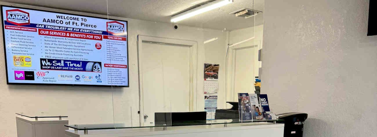 A reception area with a large screen displaying information and a desk with informational brochures.