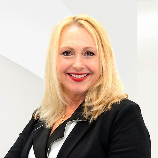 A woman with blonde hair is wearing a black jacket and red lipstick.