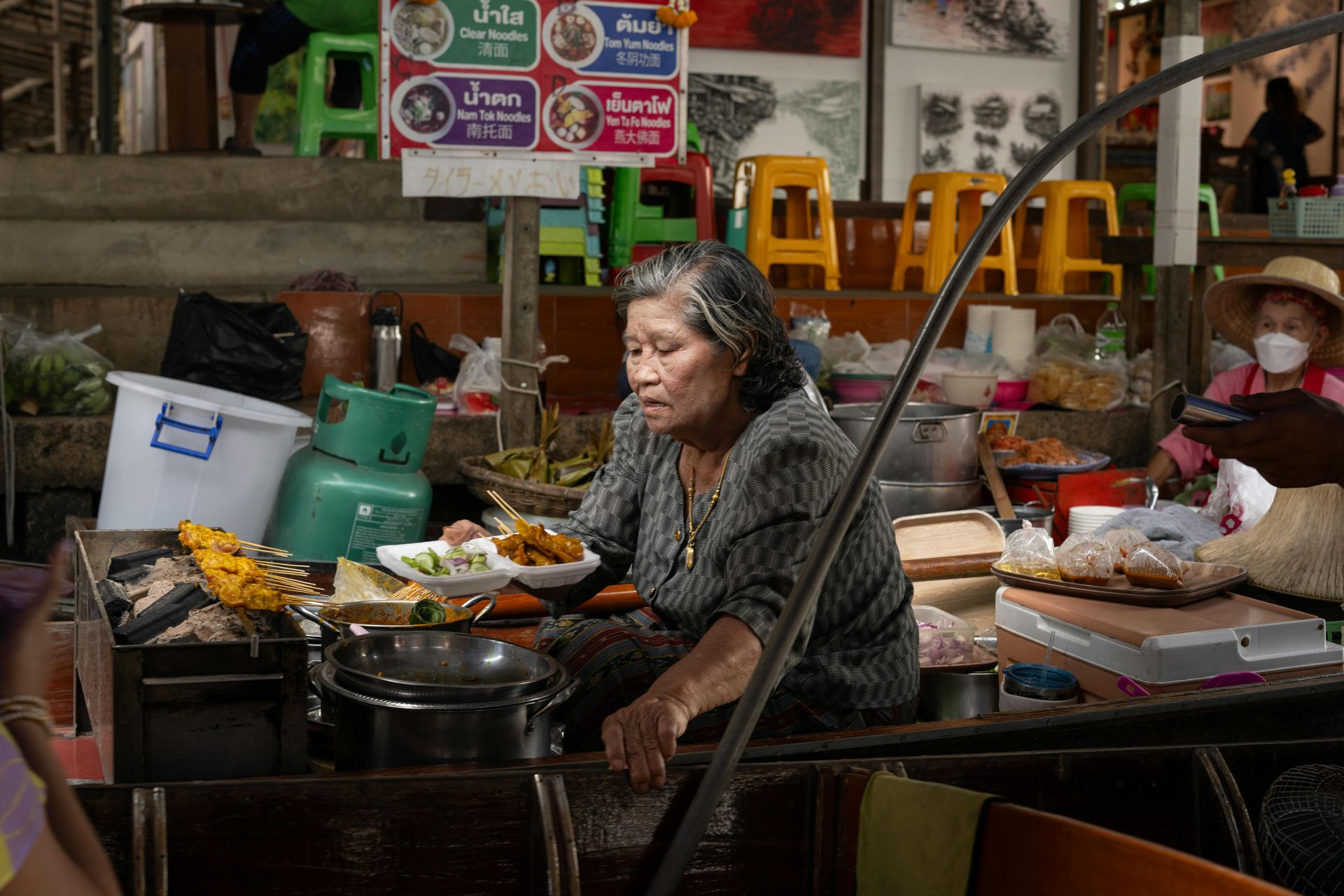 Long-tail boat on Bangkok canal khlong with traditional wooden stilt houses