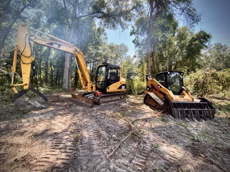 Excavator and a skid steer loader are parked next to each other in the dirt - link to Gallery