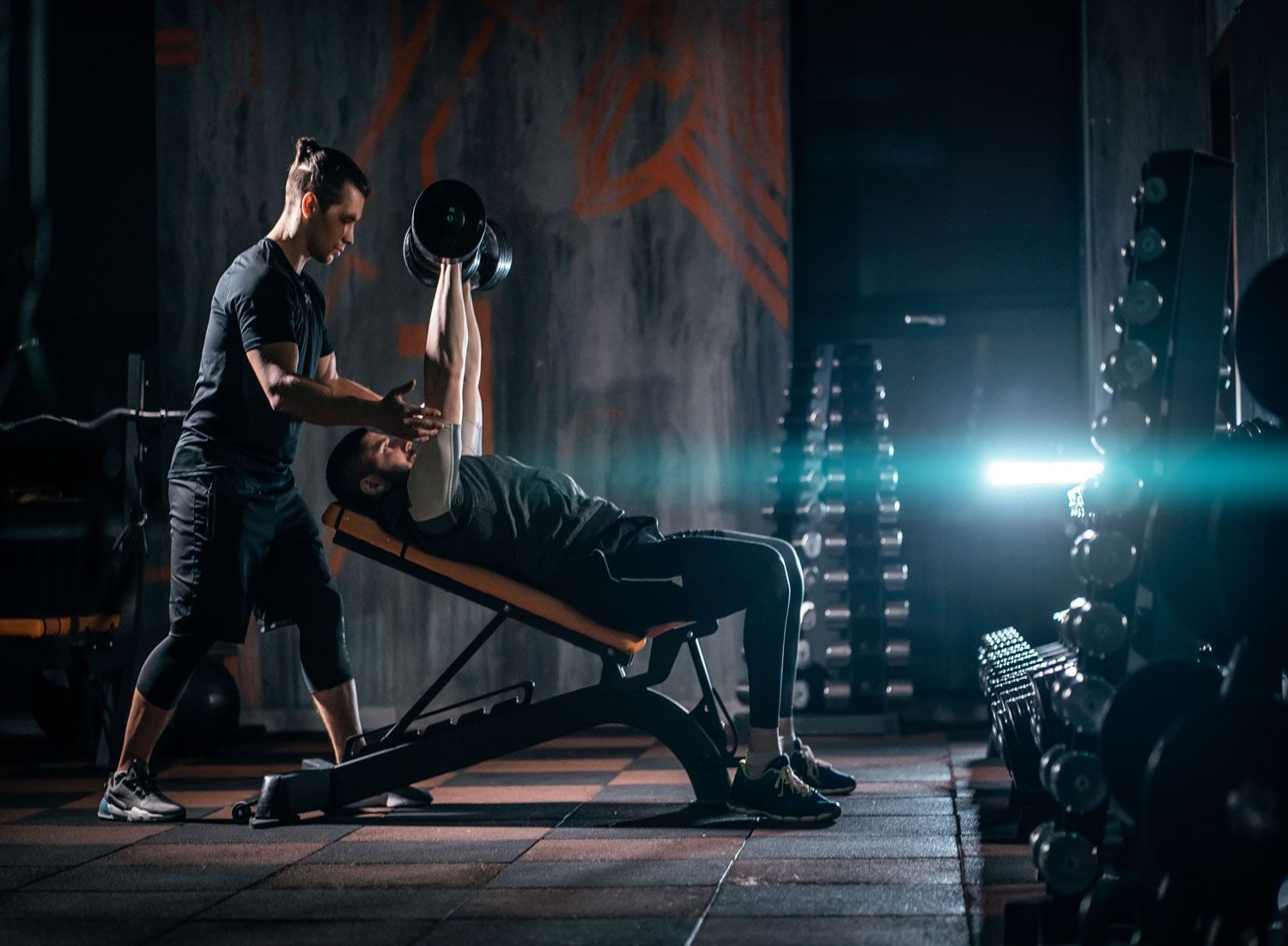 young-man-has-workout-with-personal-trainer-in-modern-gym