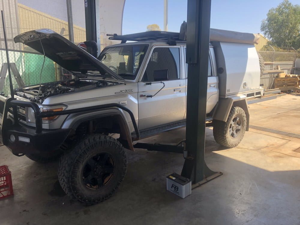 A Silver Truck With the Hood Up is Sitting on a Lift — RK Diesel Services in Ciccone, NT