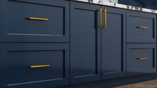 A kitchen with blue cabinets and gold handles.