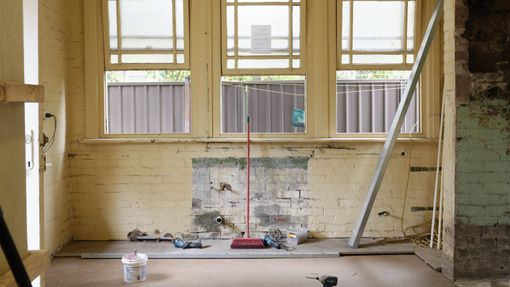 An empty room with a window and a broom on the floor